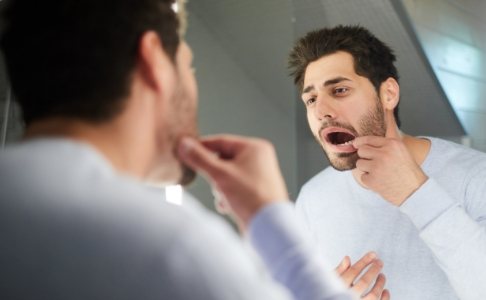 Man looking at damaged smile before emergency dentistry treatment