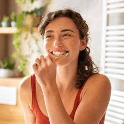 person brushing their teeth and smiling