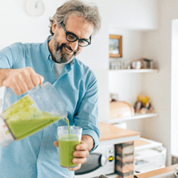 person pouring a smoothie out of a blender