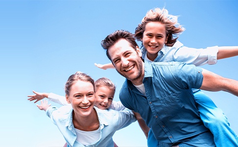 Family with healthy smiles after visiting the dentist